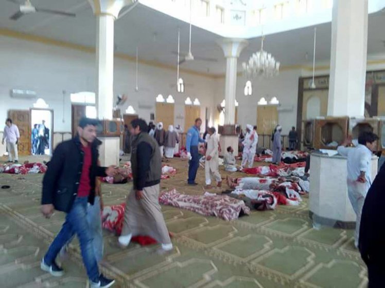 epa06347847 People sit next to bodies of worshippers killed in attack on mosque in the northern city of Arish, Sinai Peninsula, Egypt, 24 November 2017. According to initial reports, dozens were killed and injured in a bombing and gunfire targeting worshipers leaving the Friday prayers in the northern city of Arish.  EPA/STR ATTENTION EDITORS: PICTURE CONTAINS GRAPHIC CONTENT - BEST QUALITY AVAILABLE