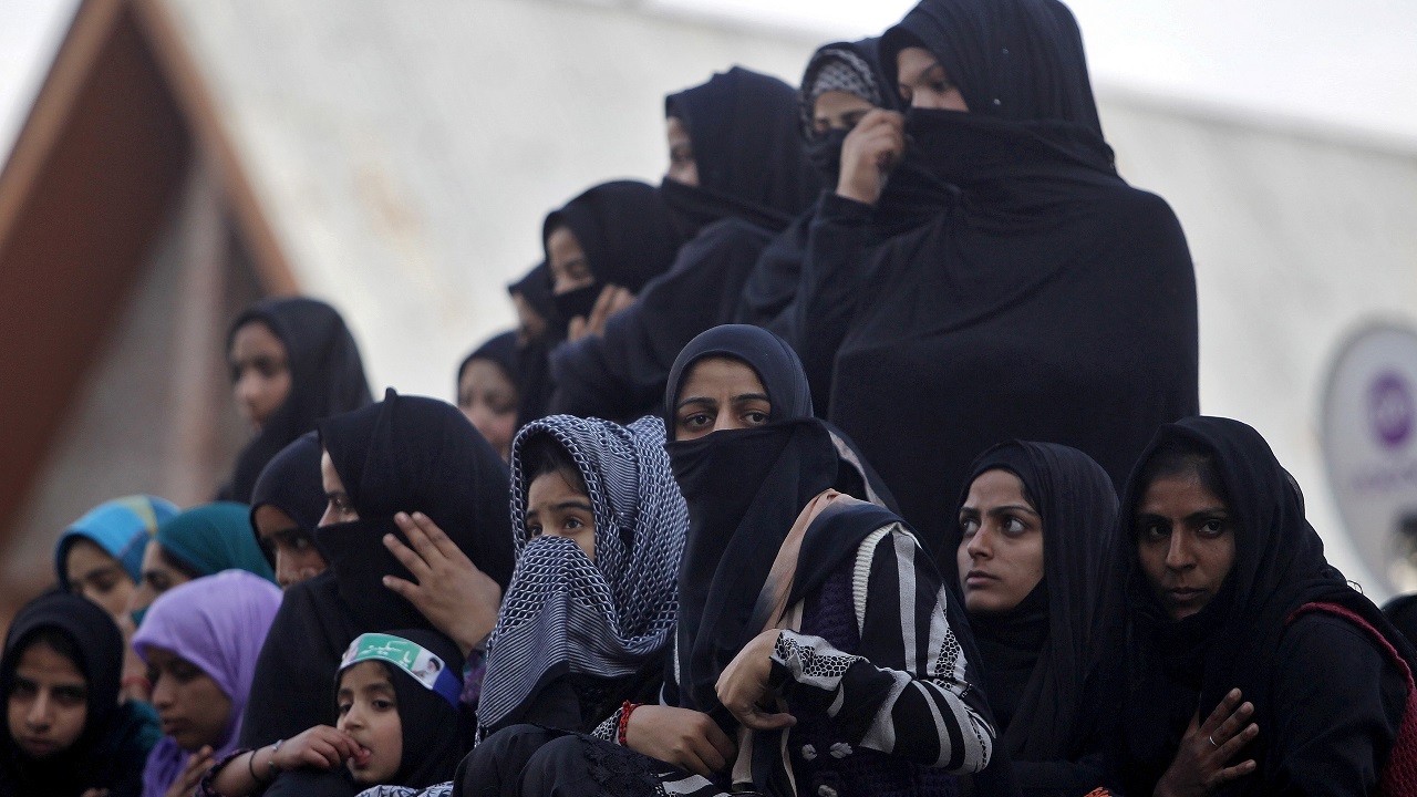 Kashmiri Shi'ite Muslim women and girls watch a Muharram procession ahead of Ashura in Srinagar October 21, 2015. Ashura, which falls on the 10th day of the Islamic month of Muharram, commemorates the death of Imam Hussein, grandson of Prophet Mohammad, who was killed in the 7th century battle of Kerbala. REUTERS/Danish Ismail   - RTS5FZ1