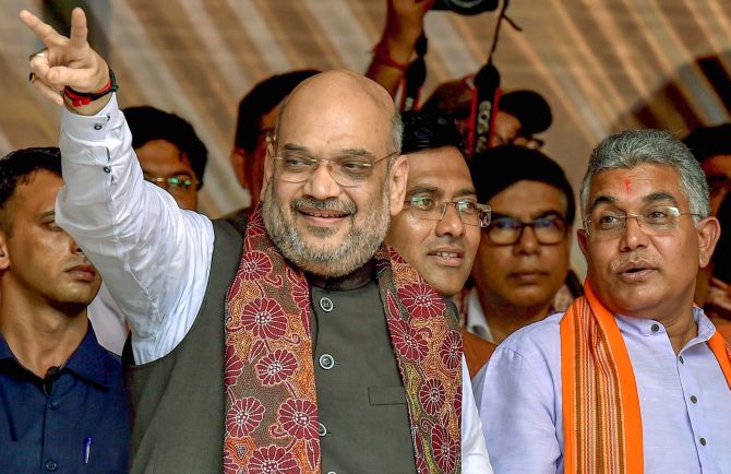 Kolkata: BJP National President Amit Shah flashes the victory sign as West Bengal BJP President Dilip Ghosh (R) looks on, during a public rally in Kolkata on Saturday, August 11, 2018. (PTI Photo/Swapan Mahapatra)   (PTI8_11_2018_000109B)