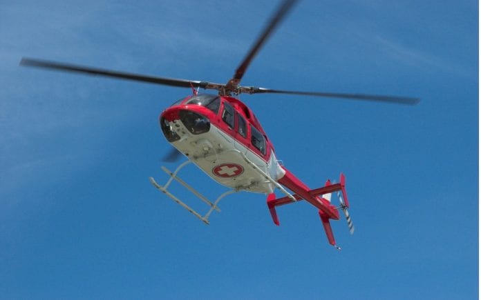 closeup-of-flying-red-helicopter-in-contrast-with-blue-sky-picture-id174905087-1-696x435
