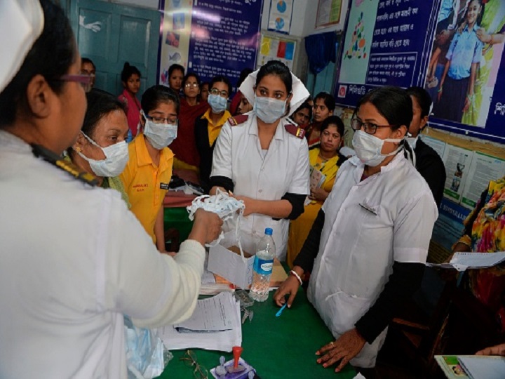 Nurses and medical staff distribute protective facemasks to patients coming to the outdoor patient department (OPD) for an awareness event about the COVID-19 coronavirus and other airborne diseases at the Siliguri District Government hospital in Siliguri on February 21, 2020. (Photo by DIPTENDU DUTTA / AFP) (Photo by DIPTENDU DUTTA/AFP via Getty Images)