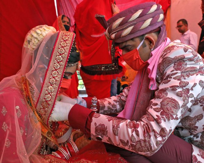 Delhi, May 10 (ANI): An Indian couple performs marriage rituals wearing a protective mask on their wedding after the government eased a nationwide lockdown imposed as a preventive measure against the spread of the COVID-19 coronavirus, in New Delhi on Sunday. (ANI Photo)