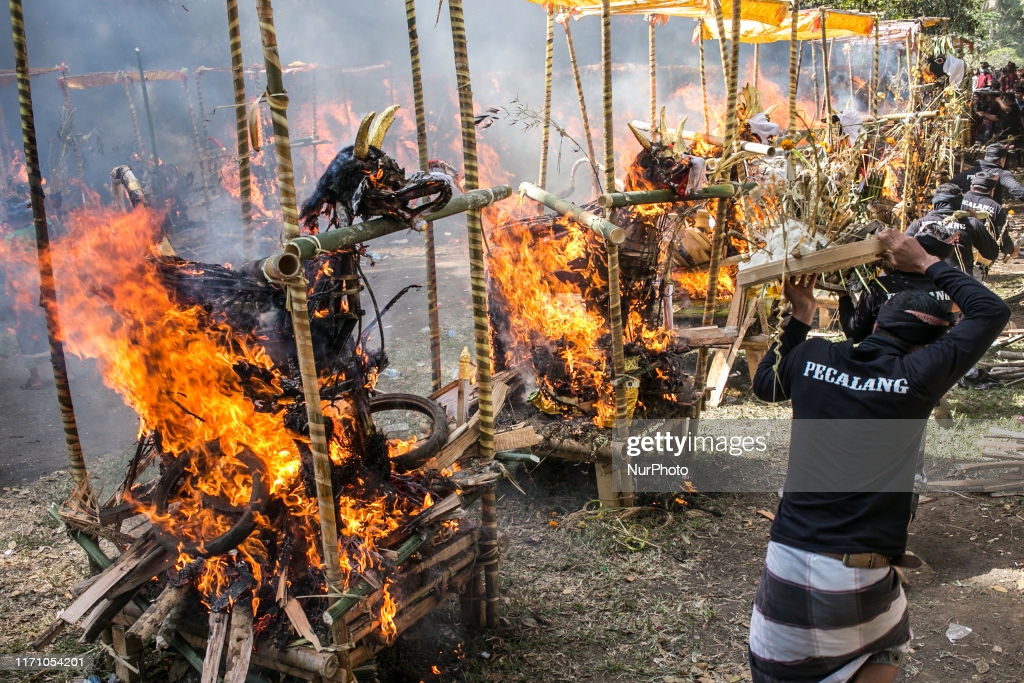 Coffin in shape of mythical dragon and bull being burnt during mass cremation or locally called Ngaben rituals in the grave yard of Bayad Village in Tegallalang, Gianyar, Bali on September 25, 2019. A total of 59 bodies in the form of human skeletons that died several years ago were cremated simultaneously in order to ease the cost of the ceremony for local residents. (Photo by Johanes Christo/NurPhoto via Getty Images)